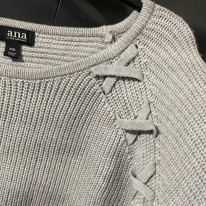 Cute grey sweater. It has cross detailing at the shoulder and down the front